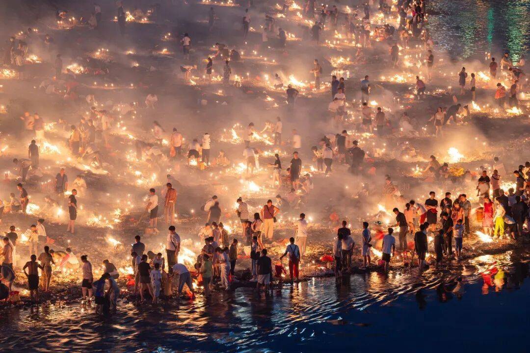 贵州凯里龙头河沿岸，大量市民在连片火光中焚纸祭亲